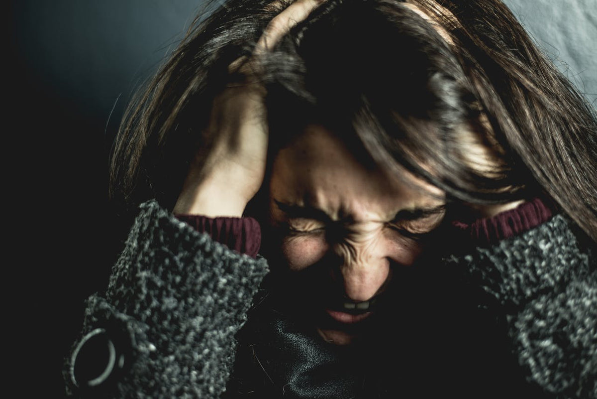 women holding hear head in pain