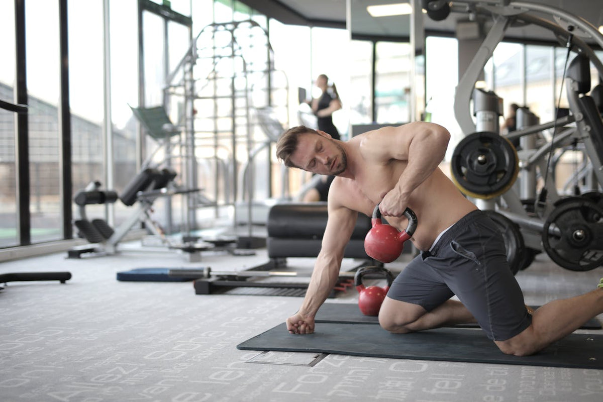 Man Kneeling on Black Mat Lifting Dumbbell