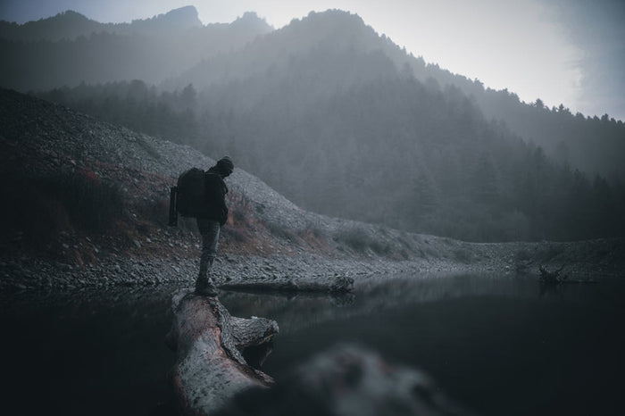 Man standing on log in water