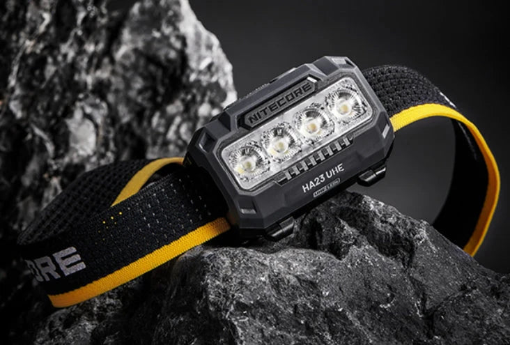 Nitecore HA23 UHE black headlamp resting on rocks